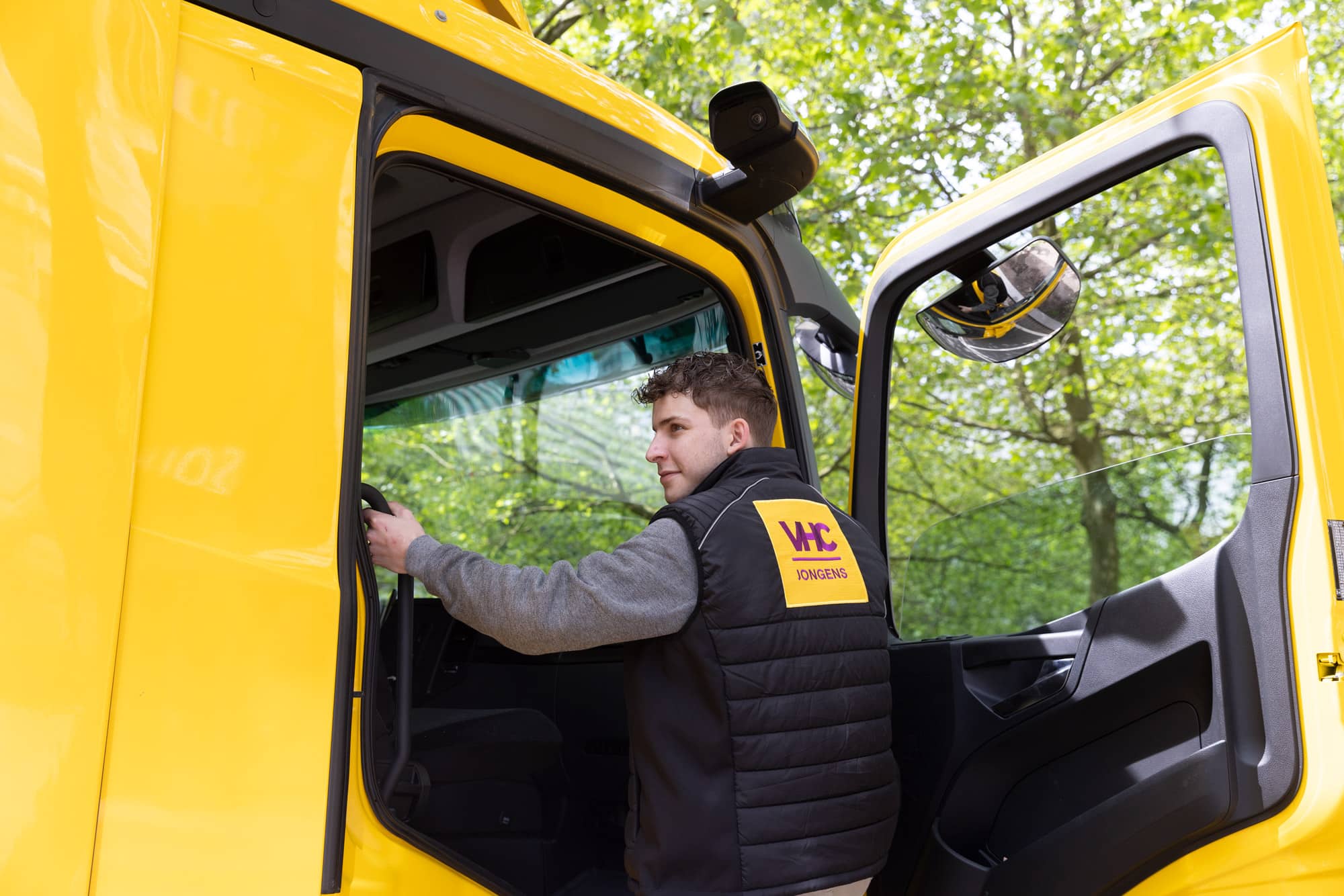 Bezorger in VHC Jongens uniform betreedt de vrachtwagen