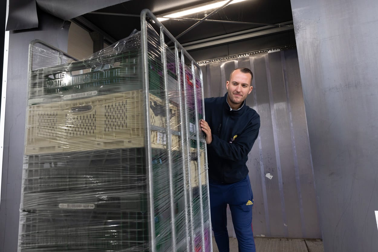 Vrachtwagenchauffeur van VHC Jongens bezig met laden/lossen van goederen